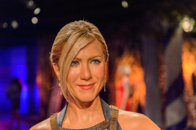 Candid shot Jennifer Aniston with her long blonde hair pulled back to an upstyle hairstyle with side bangs at the Madame Tussauds museum in SF 2014.