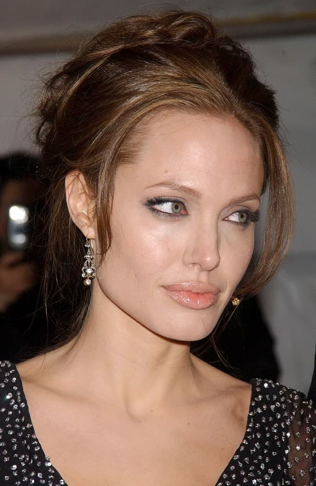 Angelina Jolie's lovely black bejeweled dress paired quite well with her loose and messy upstyle hair with tendrils and bangs at the Premiere of THE GOOD SHEPHERD in Ziegfeld Theatre, New York on December 11, 2006.