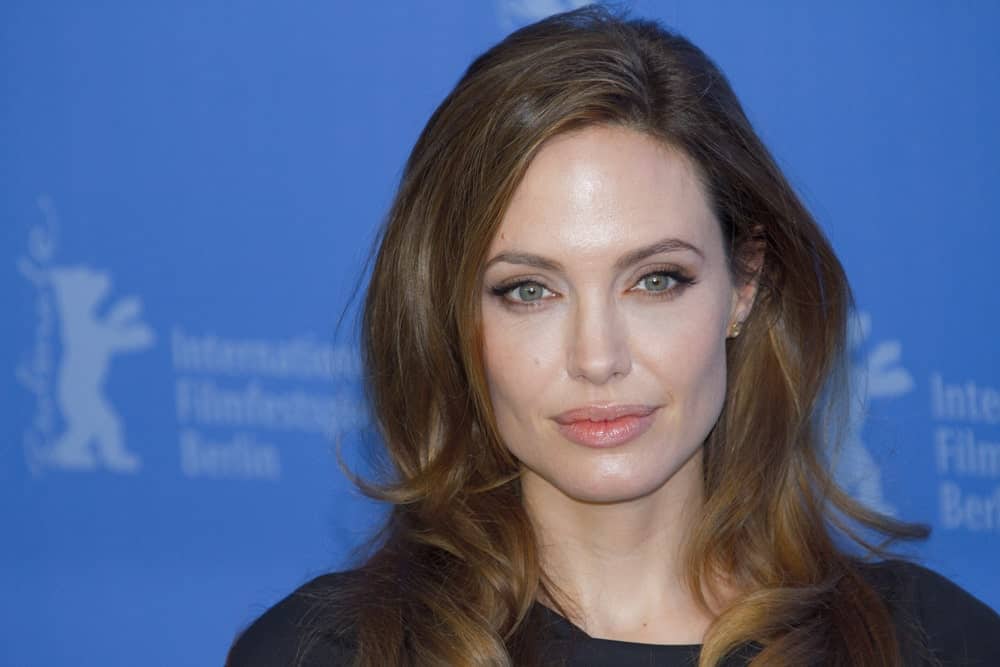 Angelina Jolie attended the 'In The Land Of Blood And Honey' Photocall during of the 62nd Berlin Film Festival at the Grand Hyatt on February 11, 2012 in Berlin, Germany. She wore simple make-up to match her black outfit and loose tousled brunette hairstyle with layers and curls.