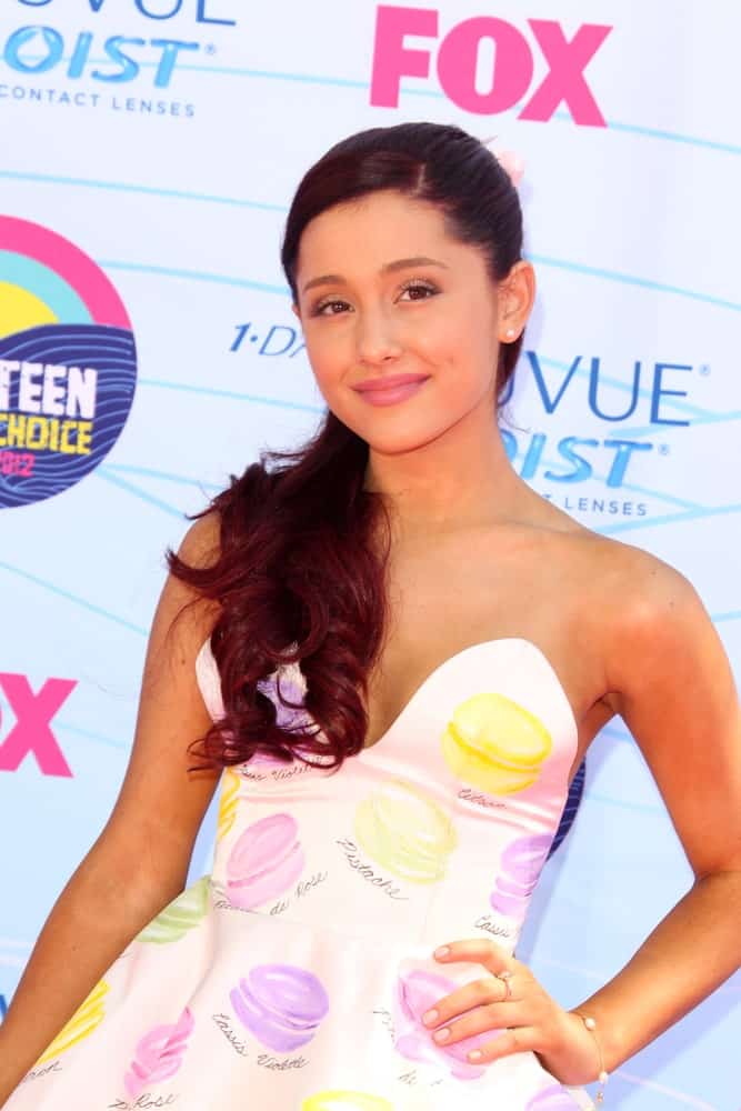 Ariana Grande at the 2012 Teen Choice Awards held on July 22, 2012. She had her dark locks styled into a side-parted half updo and gathered it on her right shoulder.
