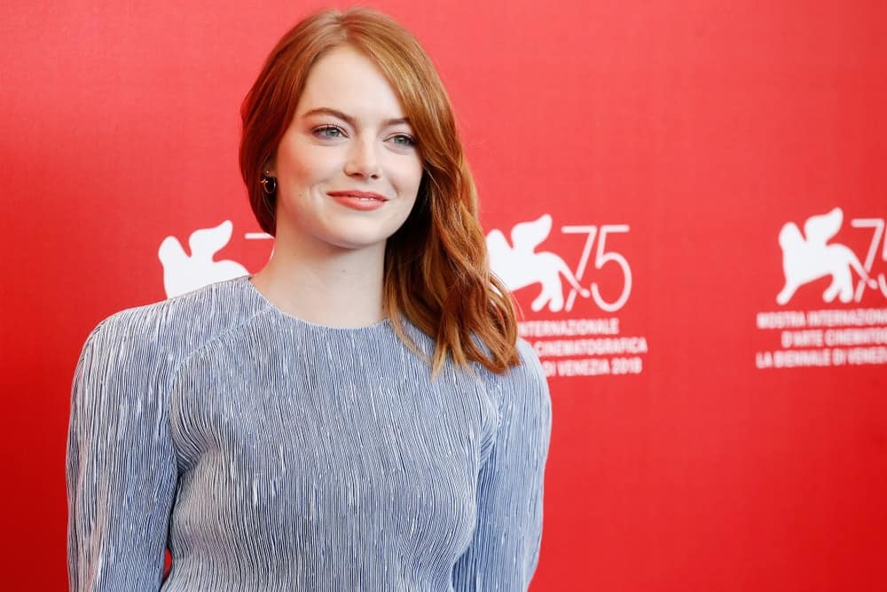 Emma Stone flaunted her natural beauty with her simple gray outfit and wavy side-swept shoulder length red hair with highlights at 'The Favourite' photo-call during the 75th Venice Film Festival on August 30, 2018 in Venice, Italy.