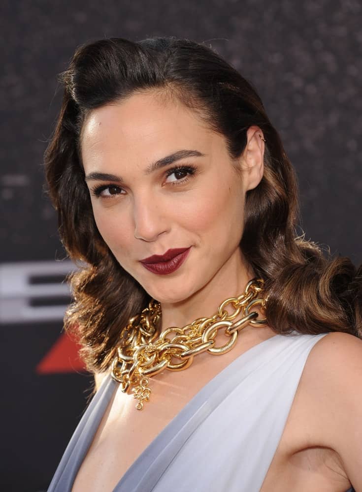 Gal Gadot attended the "Fast & Furious 6" US Premiere on May 21, 2013 in Hollywood, CA. She wore a golden chain accessory to match her vintage curly hairstyle with a pompadour finish.