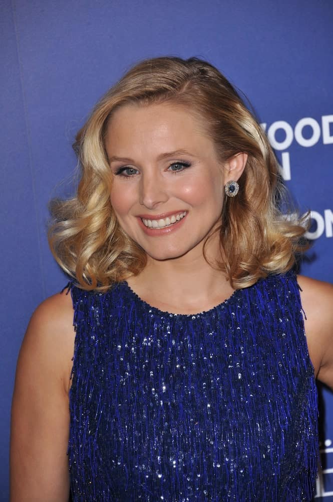 Kristen Bell in a blue sparkling dress that contrasts her blonde voluminous waves during the Hollywood Foreign Press Association's annual Grants Banquet on August 14, 2014.