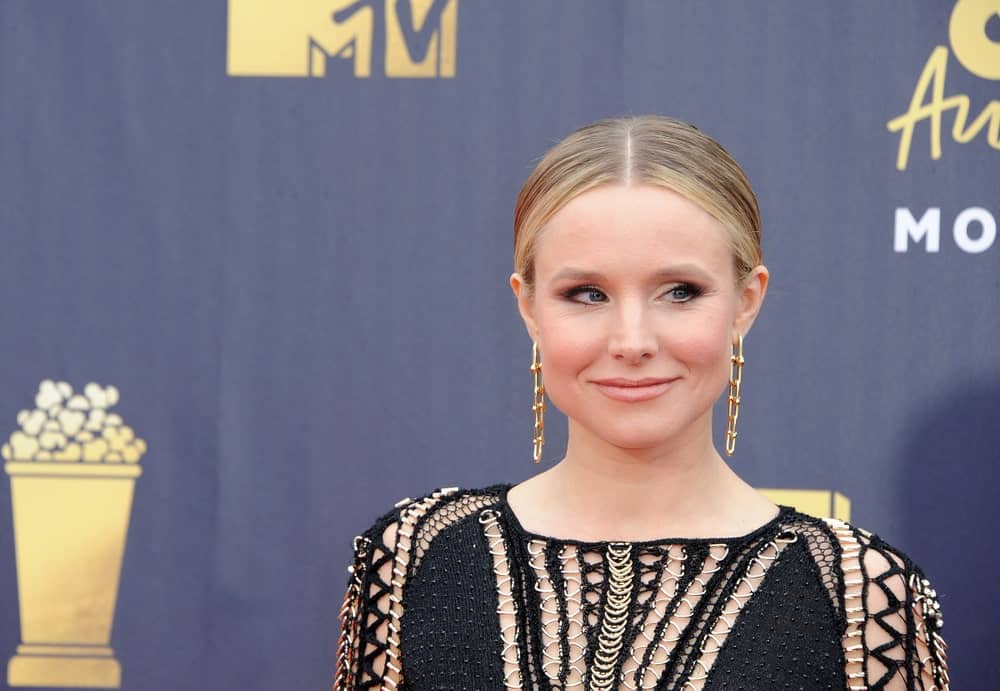 Kristen Bell emphasized her slicked updo with gold dangling earrings during the 2018 MTV Movie And TV Awards held at the Barker Hangar on June 16, 2018.