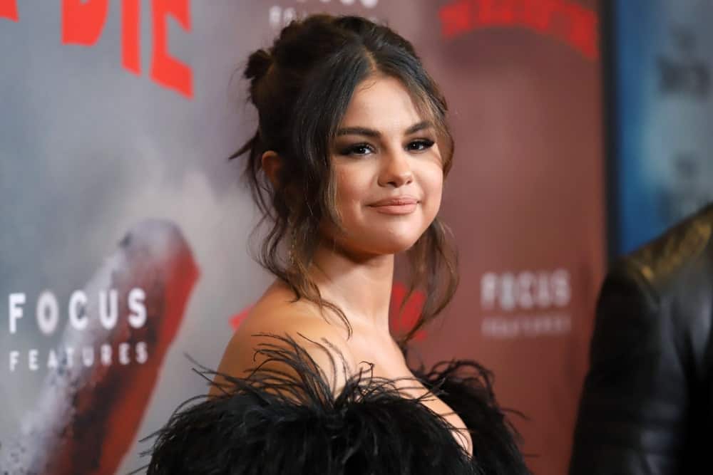 Selena Gomez emphasized her youthful glow with her lovely black dress and messy upstyle bun with loose tendrils and bangs at the premiere of "The Dead Don't Die" at the Museum of Modern Art on June 10, 2019, in New York City.