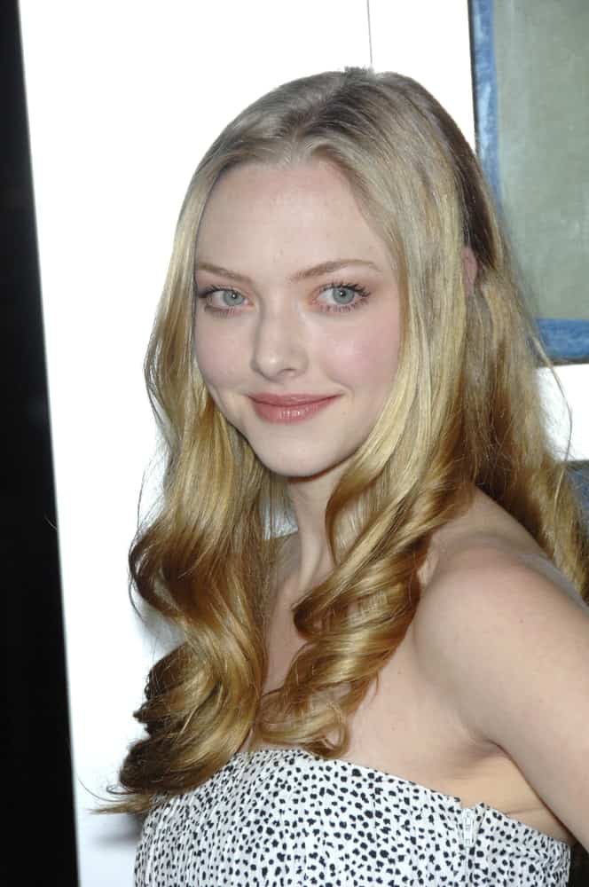 Amanda Seyfried's white patterned strapless dress complemented her loose and long sandy-blond hairstyle with highlights and tight curls at the tips at the world premiere of her new movie "Alpha Dog" at the Arclight Theatre, Hollywood on January 3, 2007, in Los Angeles, CA.