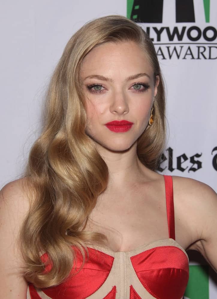 Amanda Seyfried wore a bustier-type dress with her long, side-swept wavy blond hairstyle and red lips when she arrived at the Hollywood Film Awards Gala 2012 on October 22, 2012 in Beverly Hills, CA.