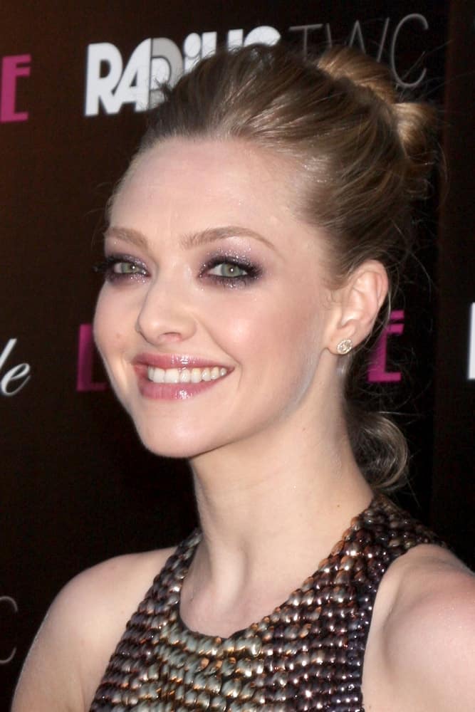 Amanda Seyfried flashed her brilliant and beautiful smile with her sexy dress and high bun hairstyle that has a slightly tousled look with loose tendrils at the 