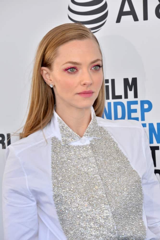 On February 23, 2019, Amanda Seyfried showcased her gorgeous green eyes with pink eye shadow, a simple white blouse and a slick straight sandy blond hairstyle loose on her back at the 2019 Film Independent Spirit Awards in Santa Monica, CA.