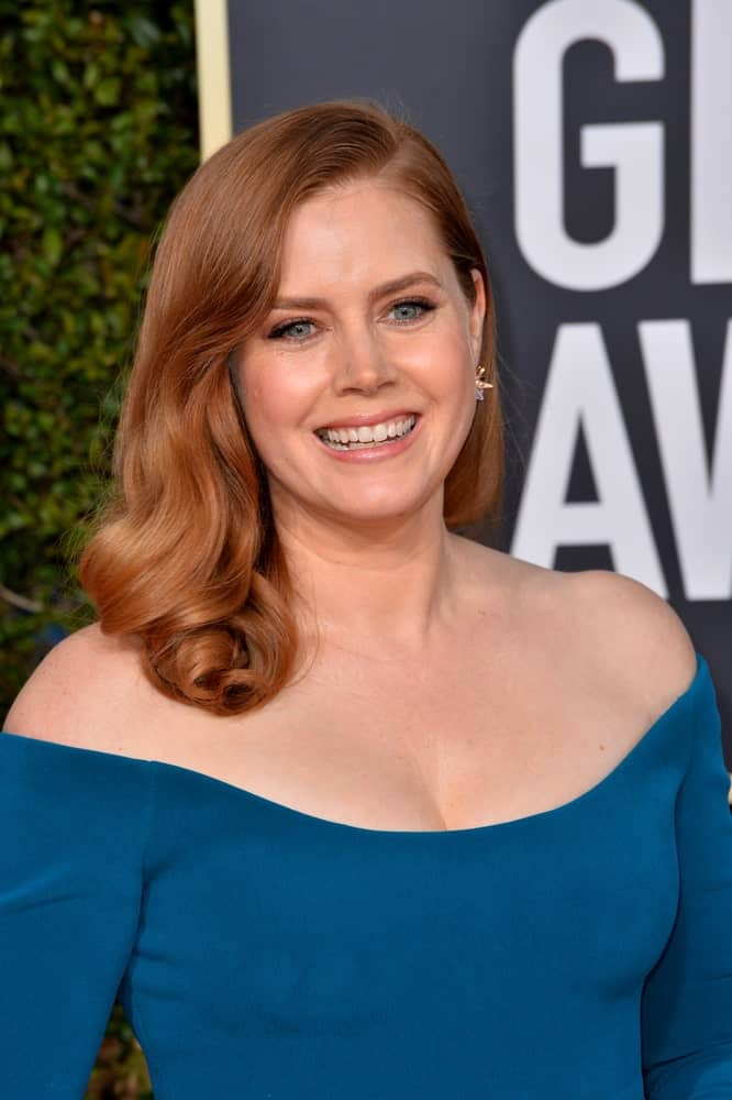 On January 06, 2019, Amy Adams attended the 2019 Golden Globe Awards at the Beverly Hilton Hotel. She wore an elegant blue dress with her loose and tousled side-swept brunette hairstyle with vintage curls.