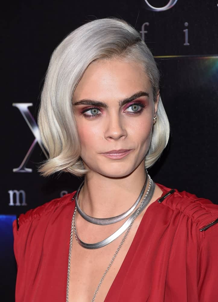 Cara Delevingne wore a charming red dress to match with her platinum blond chin-length hairstyle with a flippy finish and side-swept bangs at the CinemaCon 2017-STX Films 