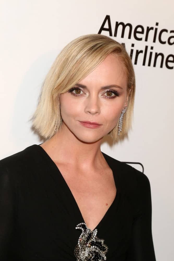 Christina Ricci was at the Elton John Oscar Viewing Party on the West Hollywood Park on February 24, 2019 in West Hollywood, CA. She wore a lovely brooch on her black dress and topped it with a chin-length straight blonde hairstyle with side-swept bangs.