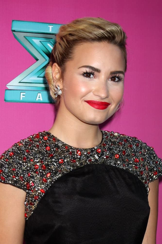 Demi Lovato was quite elegant in her bejeweled dress and bun hairstyle that has blond highlights when she arrived at the FOX Season 2 Premiere of X-Factor at Graumans Chinese Theater on September 11, 2012 in Los Angeles, CA.