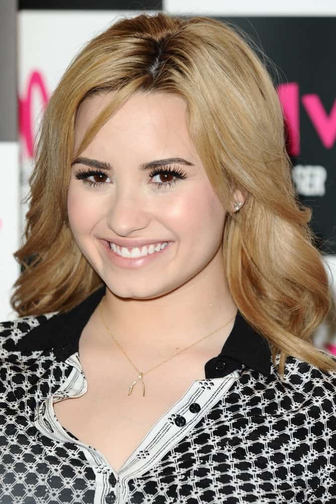 Demi Lovato signed copies of her new album "Unbroken" at the HMV Oxford Street in London on May 28, 2013. She was quite charming in her black outfit that complemented her shoulder-length blond curls with layers and highlights.