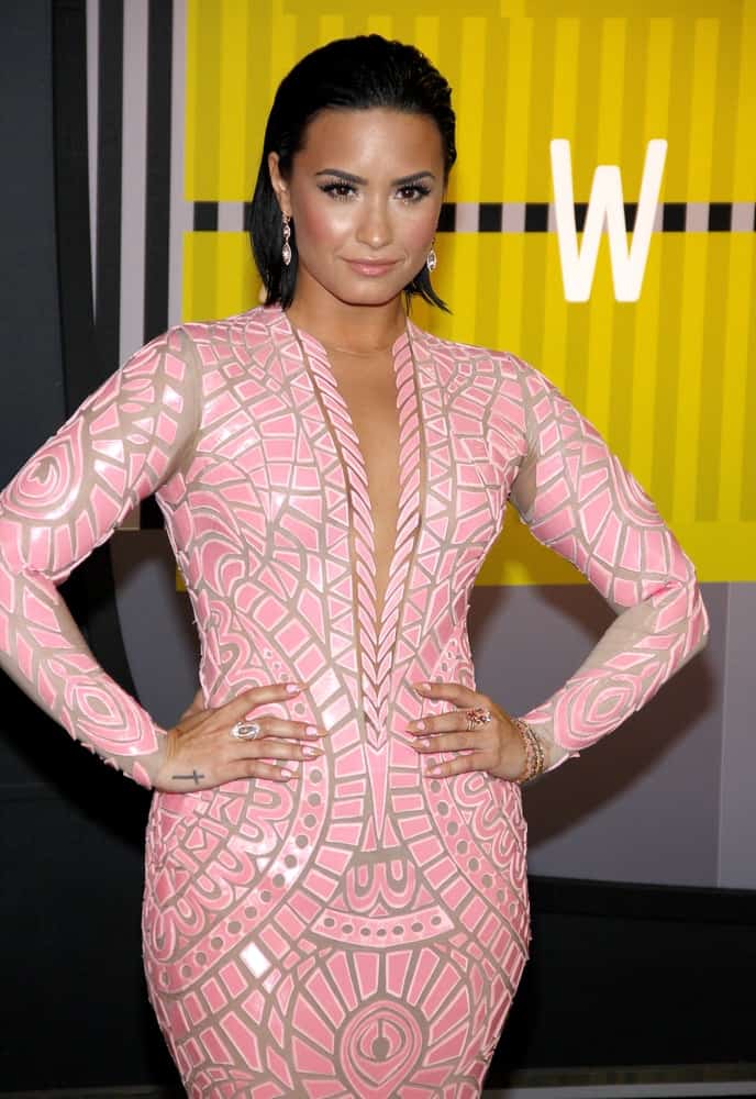 Demi Lovato paired her gorgeous pink patterned fit dress with her raven slicked back short hairstyle and confident smile at the 2015 MTV Video Music Awards held at the Microsoft Theater in Los Angeles, USA on August 30, 2015.