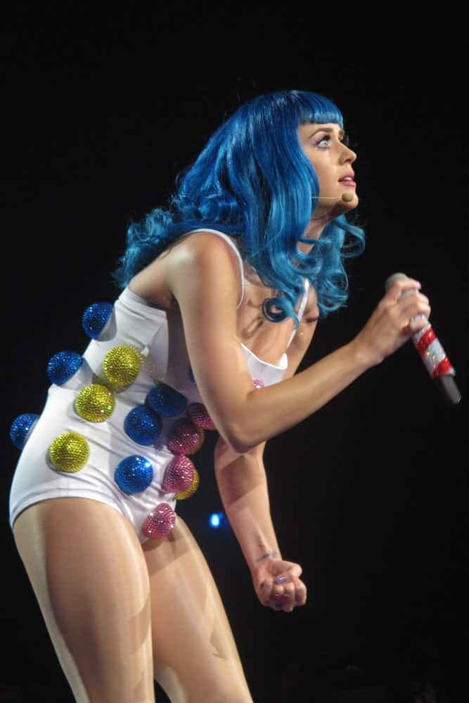 Katy Perry performing at the American leg of her "California Dreams Tour 2011" on August 5, 2011 in a quirky outfit matching her blue curly hair with short blunt bangs.