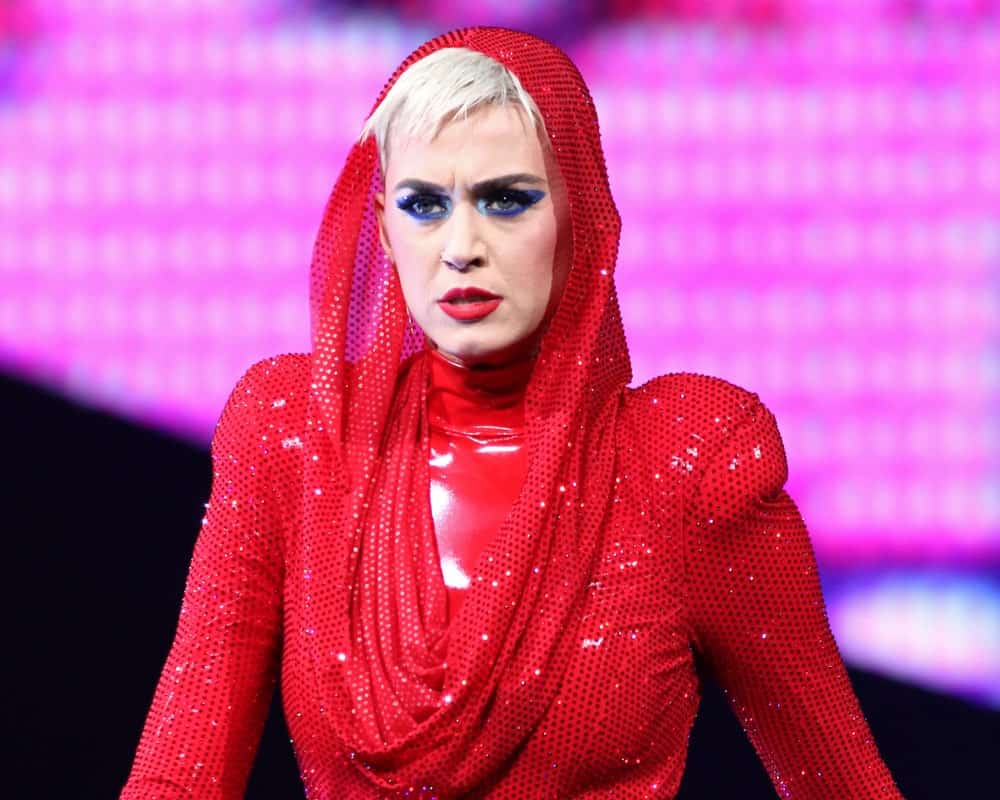 Katy Perry performing at Madison Square Garden on October 2, 2017, in New York rocking a platinum blonde pixie that's covered in a red dotted hood.