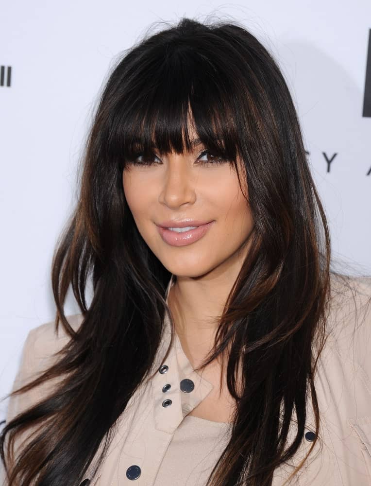 Kim Kardashian incorporates her long layered locks with eye-skimming bangs during the Tracy Anderson Flagship Studio Opening on April 04, 2013, in Hollywood, CA.