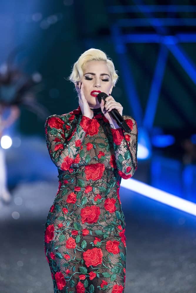 Lady Gaga performed during the Victoria's Secret Fashion Show on November 30, 2016 in Paris, France. She wore a fashionable tight dress with rose details to go with her short side-swept blond hairstyle and red lips.