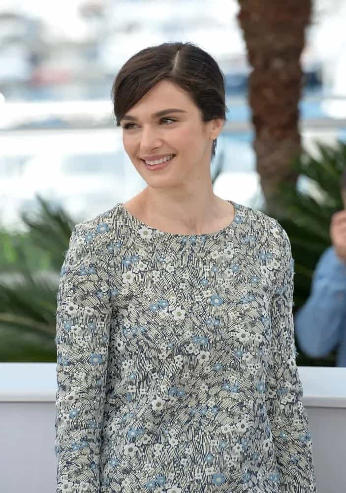 Rachel Weisz flashes a smile in a floral-patterned long sleeve dress and pulled her brunette hair back into a chic bun as she attends the photocall for her movie "Youth" at the 68th Festival de Cannes on May 20, 2015.