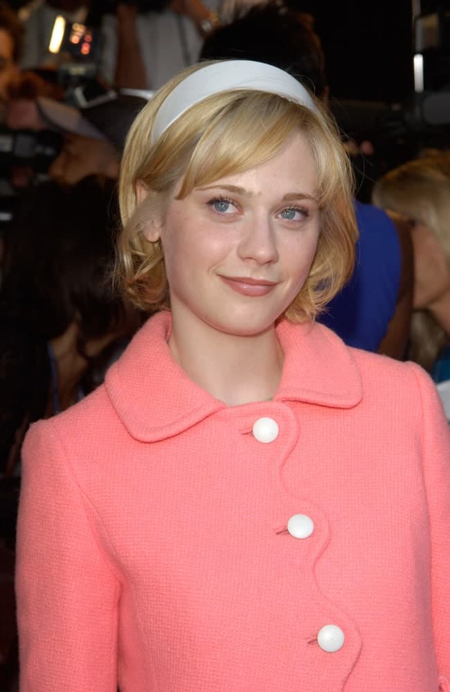 Zooey Deschanel was at the premiere of her new movie The Good Girl, the closing night movie of the 2002 IFP/West-Los Angeles Film Festival on June 29, 2002. She wore a charming pink winter coat with her chin-length blonde hairstyle with bangs and a headband.