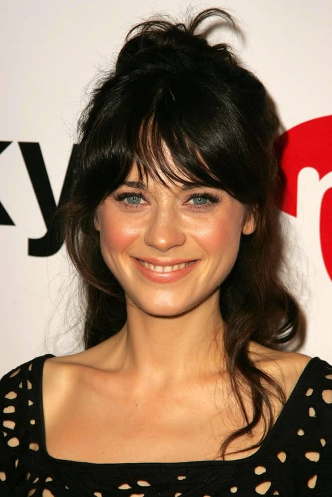 Zooey Deschanel was at the Lucky Magazine LA Shopping Guide Party on August 10, 2006 in Milk, West Hollywood, CA. She was charming in a black dress and messy tousled raven hairstyle with bangs and a bun.