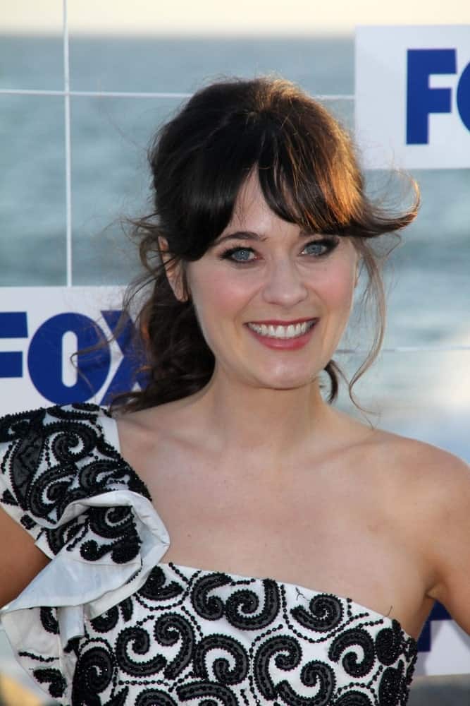 Zooey Deschanel was at the FOX All Star Party 2011 in Gladstones, Malibu, CA on August 5, 2011. She was seen wearing a black and white dress with a messy ponytail hairstyle that has long bangs.