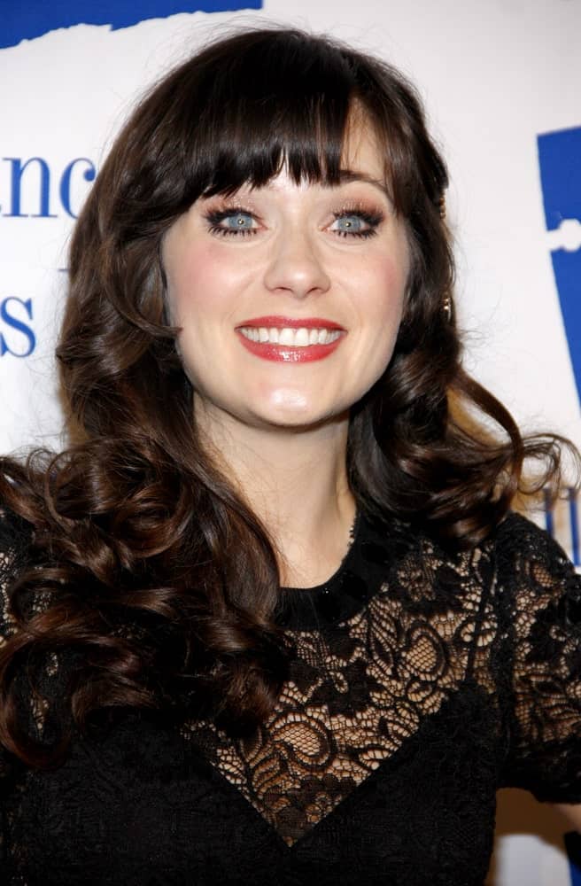 Zooey Deschanel was at the Alliance for Children's Rights Dinner Honoring Kevin Reilly held at the Beverly Hilton Hotel in Beverly Hills on March 1, 2012. She paired her black dress with a long and tousled curly dark hairstyle that is tousled and loose.