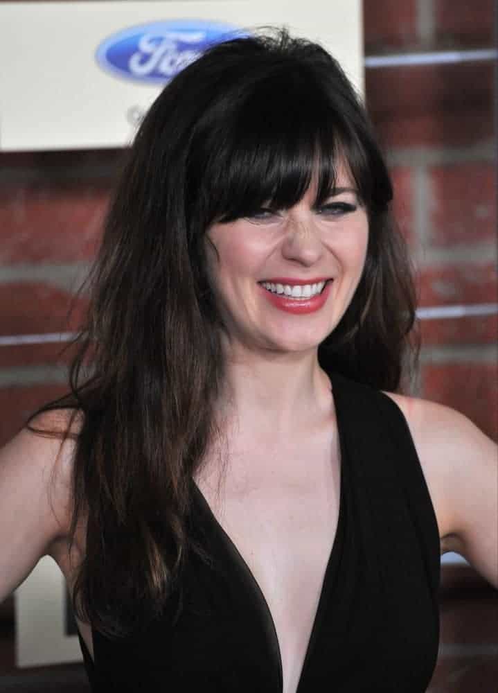 On September 10, 2012, Zooey Deschanel was at the Fox Fall Eco-Casino Party in Culver City. She was seen wearing a lovely black dress with her long and dark tousled hairstyle that is loose and has bangs.