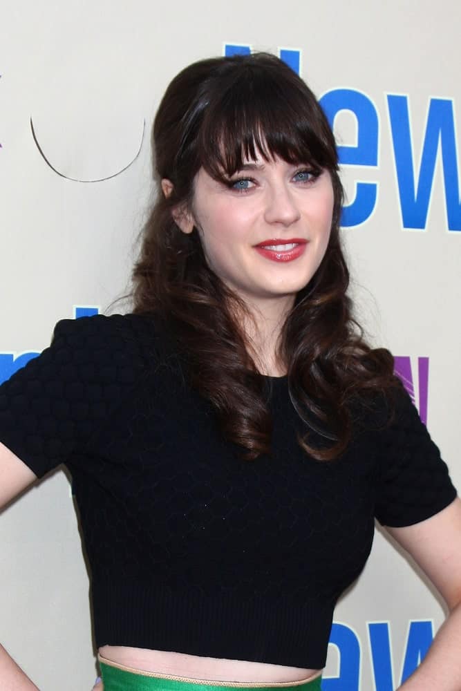 Zooey Deschanel was at the An Evening with "New Girl" at the Academy of Television Arts and Sciences on April 30, 2013 in North Hollywood, CA. She was wearing a black outfit with her dark brunette half-up hairstyle that has curls and bangs.