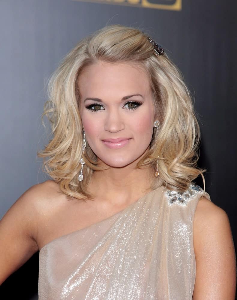 Carrie Underwood looks like a goddess in a nude halter dress along with short tousled waves that she pinned on one side during the 2009 American Music Awards on November 22, 2009.