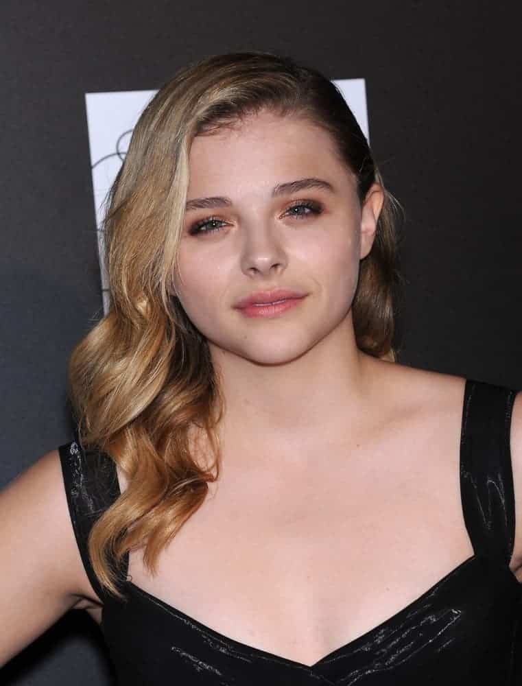 Chloe Grace Moretz attended the 5th Annual PSLA Autumn Party on October 8, 2014, in Culver City, CA. She wore a black leather dress to pair with her side-swept sandy blonde hairstyle that has subtle highlights, layers, and waves.