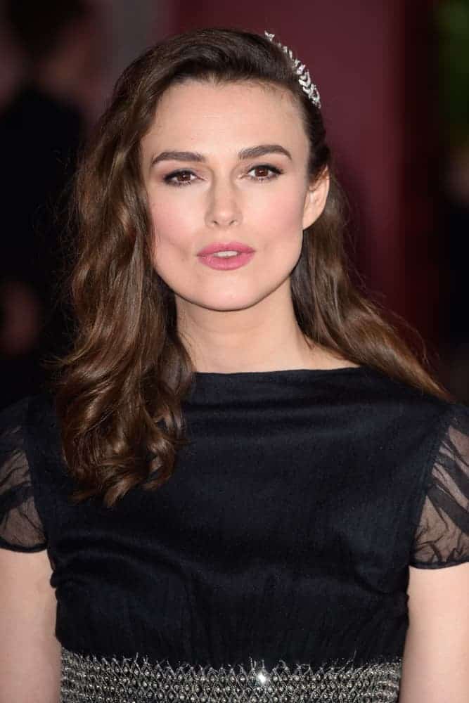 On February 18, 2019, Keira Knightley attended the premiere of "The Aftermath" at the Picturehouse in Central, London. She was quite lovely in her black dress with silver accents to match with her side-swept wavy dark brown layers with a slight tousle.