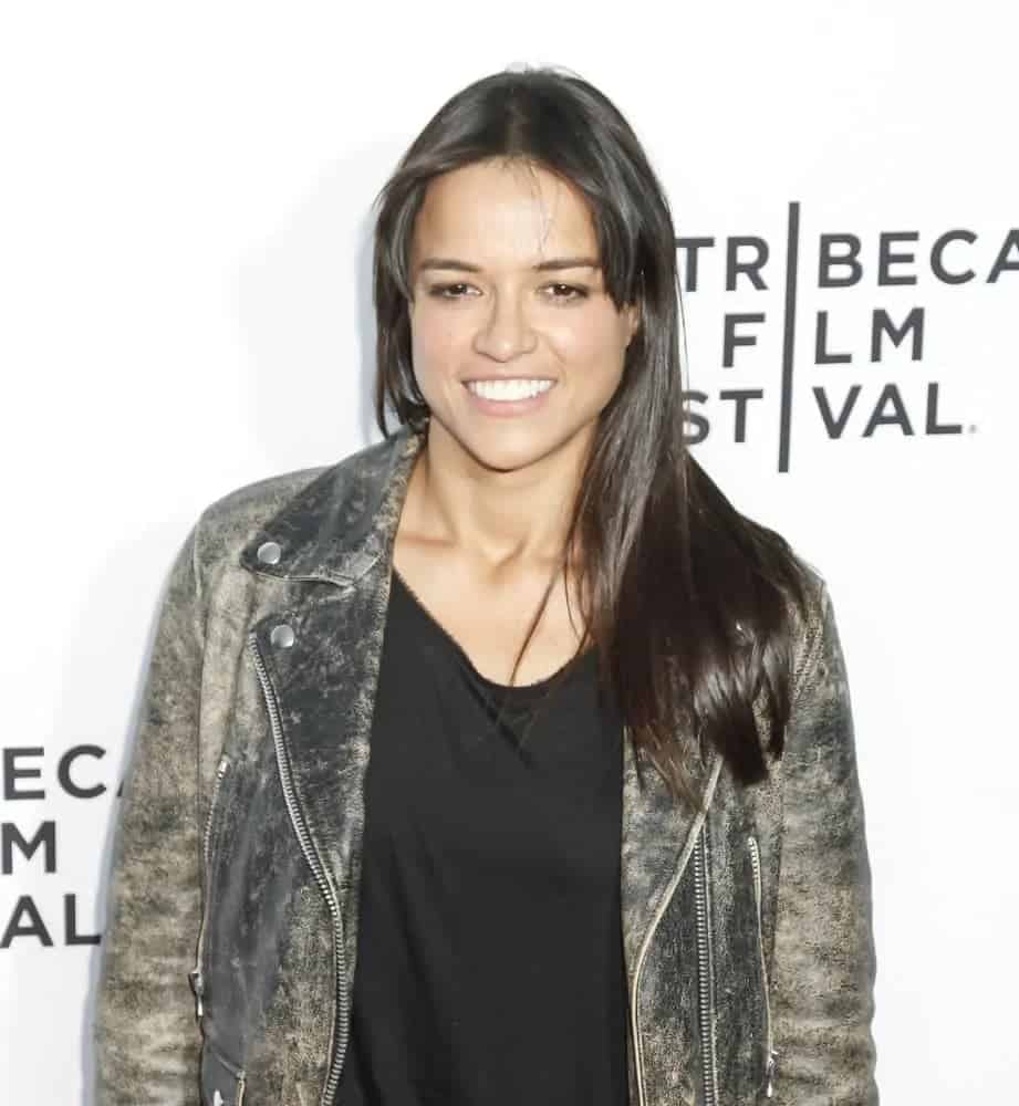 Michelle Rodriguez dresses down in a leather jacket and wore her sleek medium-length hair in loose straight, rested in one shoulder with middle-part bangs at the world premiere of Live From New York on April 15, 2015.