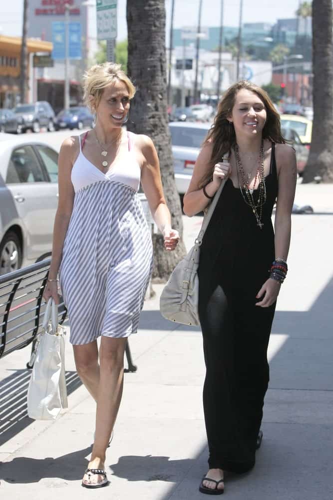 Miley Cyrus was out and about with her mother walking the streets of Beverly Hills, CA on May 23, 2009. Miley was quite lovely in her simple black dress and loose tousled wavy layered hairstyle.