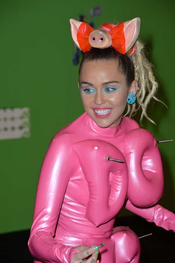 On August 30, 2015, Miley Cyrus attended the 2015 MTV Video Music Awards at the Microsoft Theatre LA Live. She embraced her quirky side with a latex pink body suit with inflatable letters that she paired with a high ponytail with blond dyed braids.