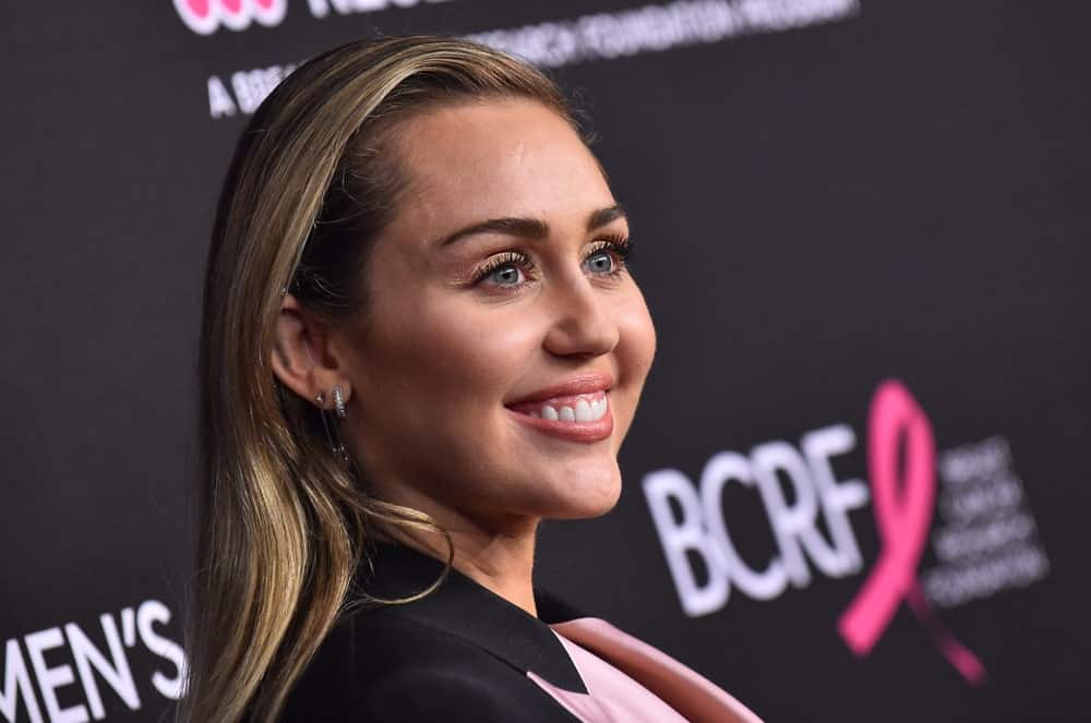Miley Cyrus flashed her bright smile that went great with her smart casual outfit and slick side-swept sandy blond hairstyle when she arrived to the "An Unforgettable Evening" on February 28, 2019 in Hollywood, CA.