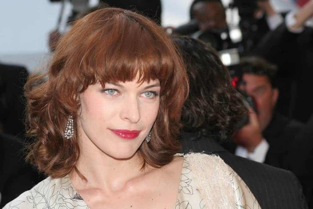 Milla Jovovich attended the screening of 'Three Burials of Melquiades Estrada' at the Grand Theatre during the 58th Cannes Film Festival on May 20, 2005, in Cannes, France. She was stunning in her beige dress and tousled shoulder-length hair with bangs and a reddish tone.