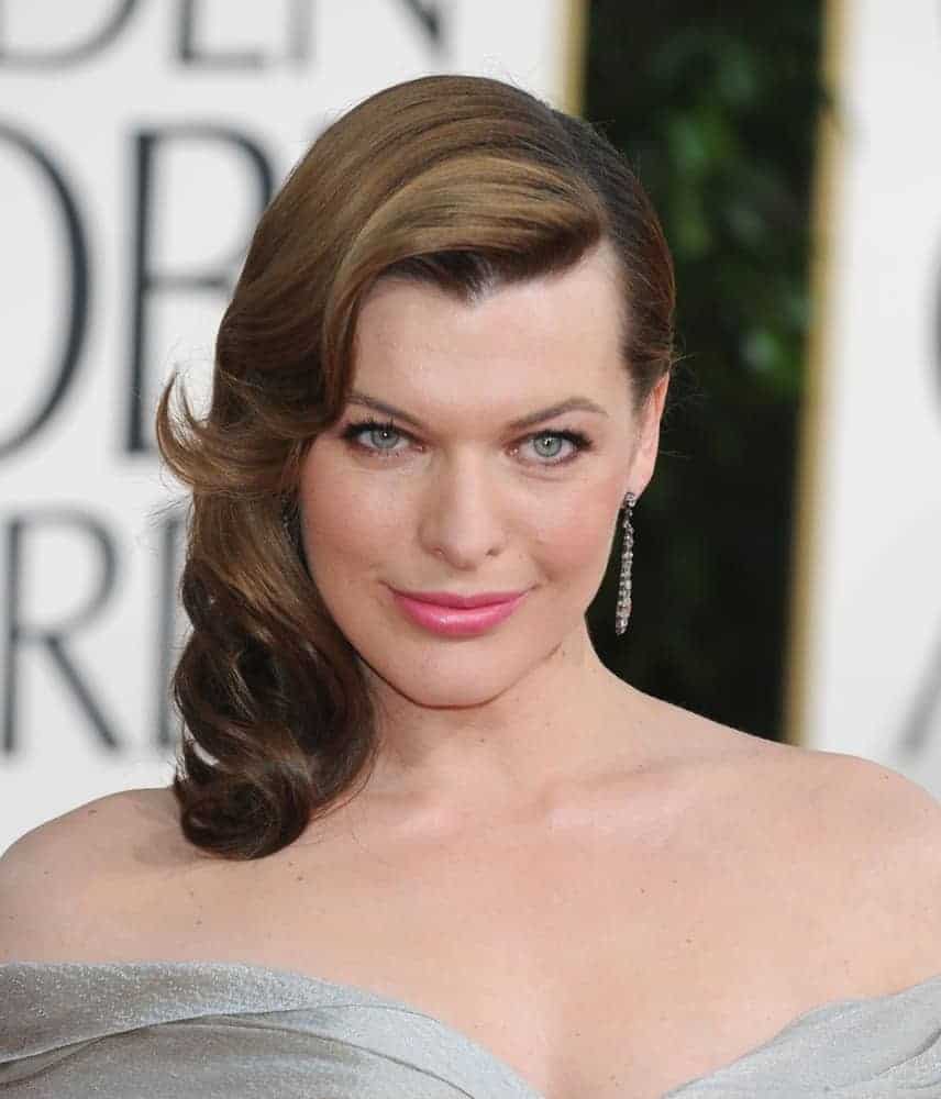 Milla Jovovich attended the 68th Annual Golden Globe Awards on January 16, 2011, in Beverly Hills, CA. She wore a lovely silvery dress that paired perfectly with a side-swept wavy and layered brunette hairstyle.