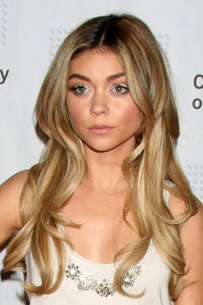 Sarah Hyland was at the American Casting Society presents 30th Artios Awards at a Beverly Hilton Hotel on January 22, 2015 in Beverly Hills, CA. She paired her white dress with a long and wavy sandy blond hairstyle with layers loose on her shoulders.