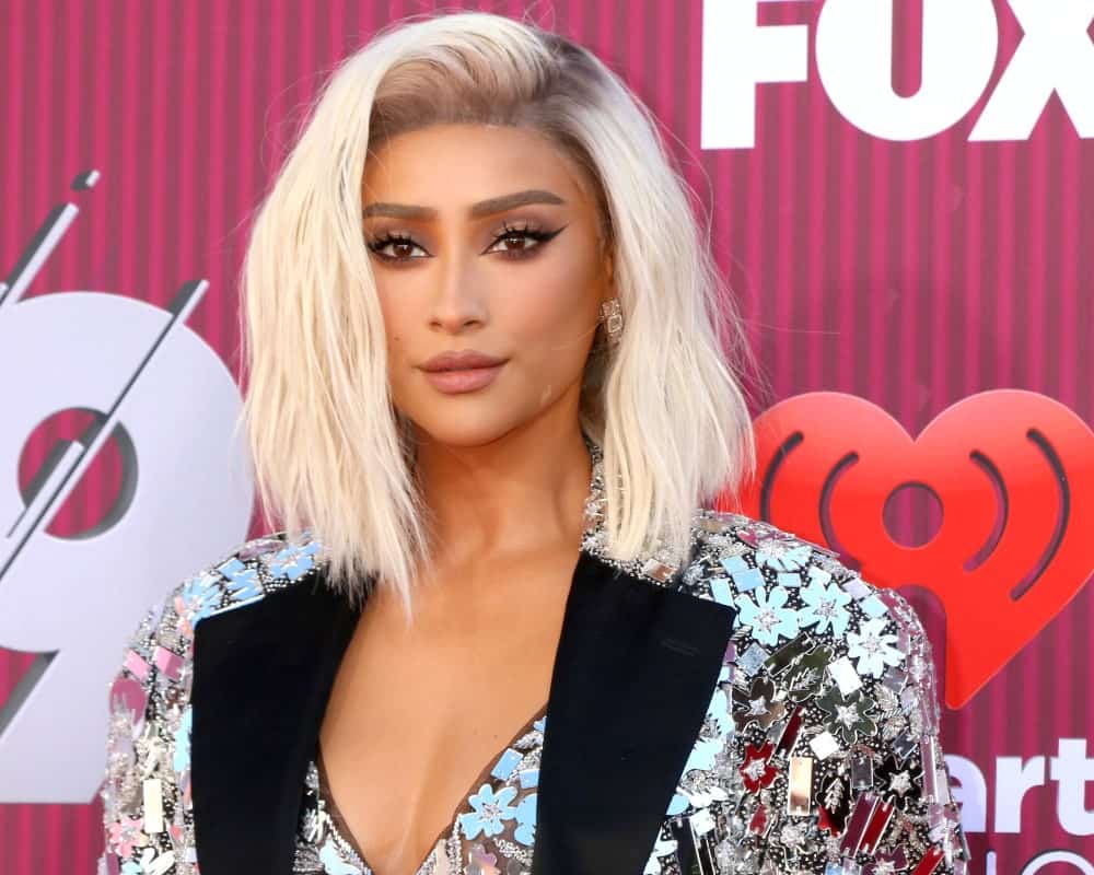 Shay Mitchell arrived at the iHeart Radio Music Awards on March 14, 2019, wearing her platinum blonde hair that's side-swept and tousled.