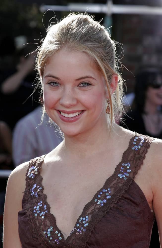 On October 9, 2005, Ashley Benson attended the DreamWorks Pictures Premiere of 'Dreamer' at the Mann Village Theatre in Westwood, CA. She wore a brown detailed blouse with her messy blonde bun hairstyle with loose tendrils and bangs.
