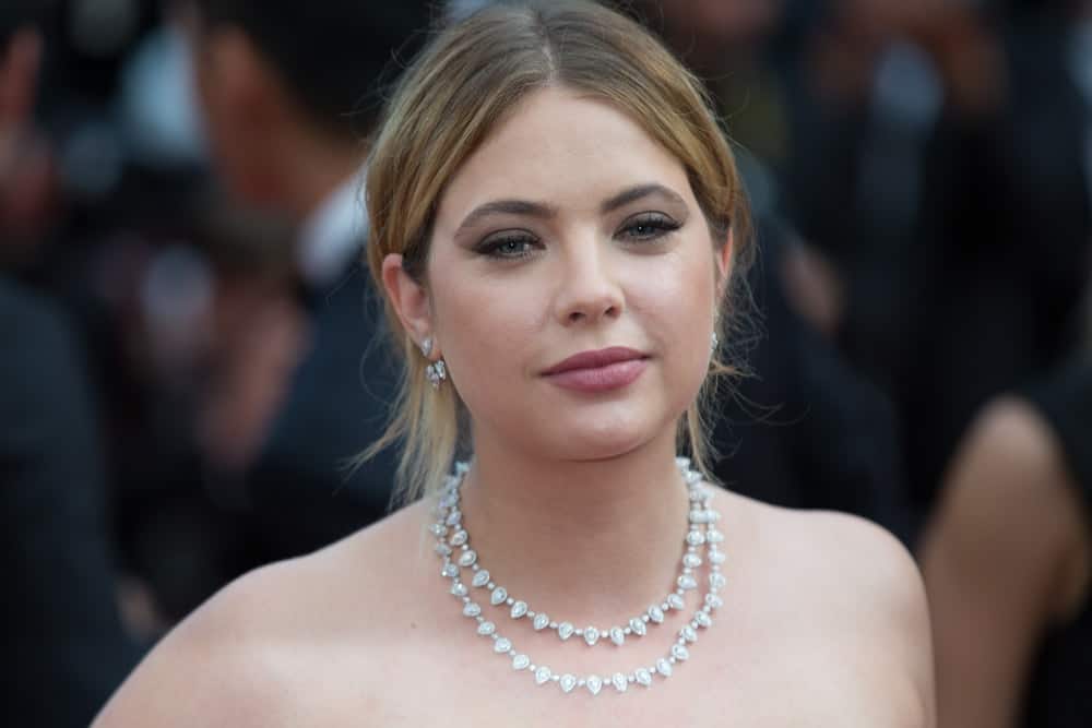 Ashley Benson attended the 70th Anniversary screening premiere at the 70th Festival de Cannes on May 23, 2017. She paired her strapless dress with an elegant necklace and a messy bun hairstyle with loose tendrils and long side bangs.