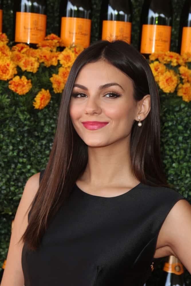 Victoria Justice was at the Sixth-Annual Veuve Clicquot Polo Classic at the Will Rogers State Historic Park on October 17, 2015 in Pacific Palisades, CA. SHe wore a black dress with her long and loose straight raven hairstyle.