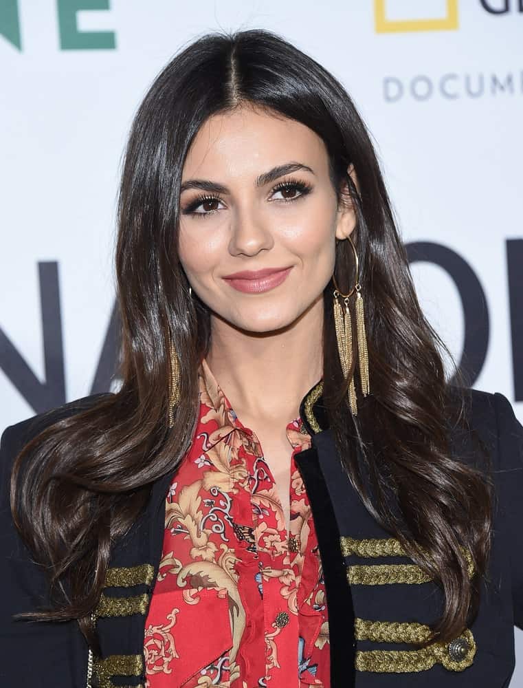 Victoria Justice attended the 'Jane' Los Angeles Premiere on October 9, 2017 in Hollywood, CA. She wore a jacket over her casual outfit and paired it with a long and loose tousled wavy brunette hairstyle with subtle highlights and layers.