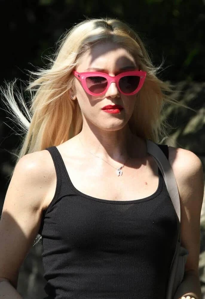 Gwen Stefani seen in Primrose Hill last Aug 1, 2013 wearing her casual black top and pink sunglasses to complement her layered and tousled straight hair.