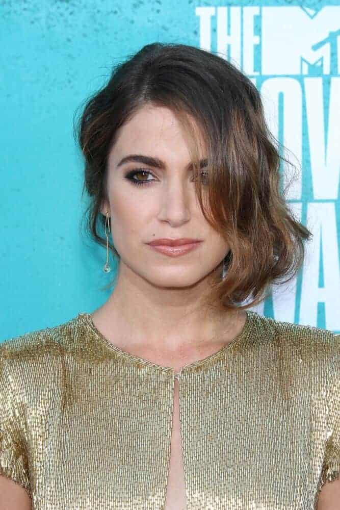 Nikki Reed once again surprised the crowd with her simple but elegant trademark look as she attended the 2012 MTV Movie Awards with a side-swept, wavy upstyle.