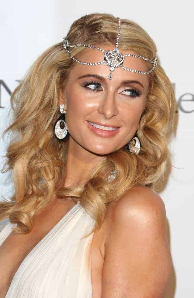 Paris Hilton at the 66th Cannes Film Festival - de Grisogono Party 2013, looking fresh and stylish with her curled hair decorated with some iconic embellishments.