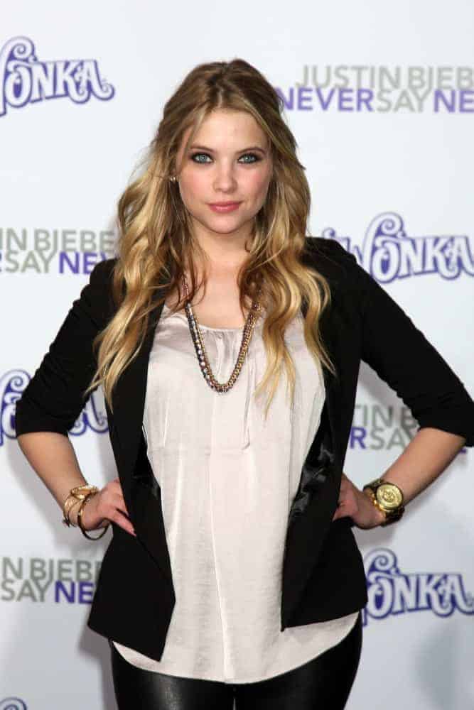 Ashley Benson arrived at the premiere of Paramount Pictures' Justin Bieber: Never Say Never at Nokia Theater L.A. Live on February 8, 2011, in Los Angeles, CA. She wore a black jacket on her casual outfit paired with a loose, tousled, and layered half-up sandy blonde hairstyle with beach waves and highlights.
