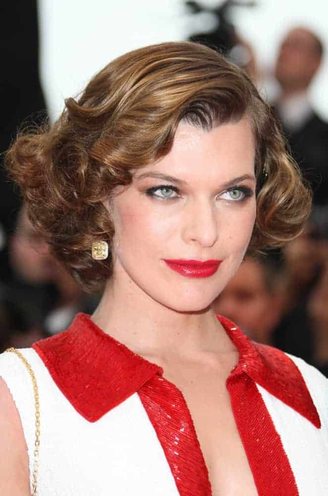 Milla Jovovich was at the 'La Conquete' Premiere, 2011 Cannes Film Festival on May 18, 2011. Her red lips were a perfect match for her dress and chin-length curly hairstyle with side-swept bangs,